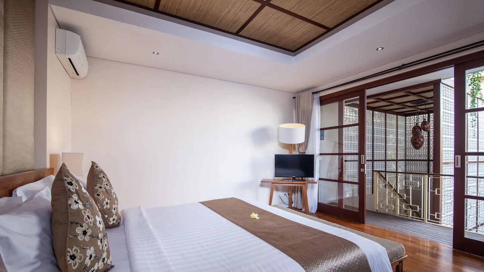 Illustrative photo of a bright bedroom with white linen and a wooden floor