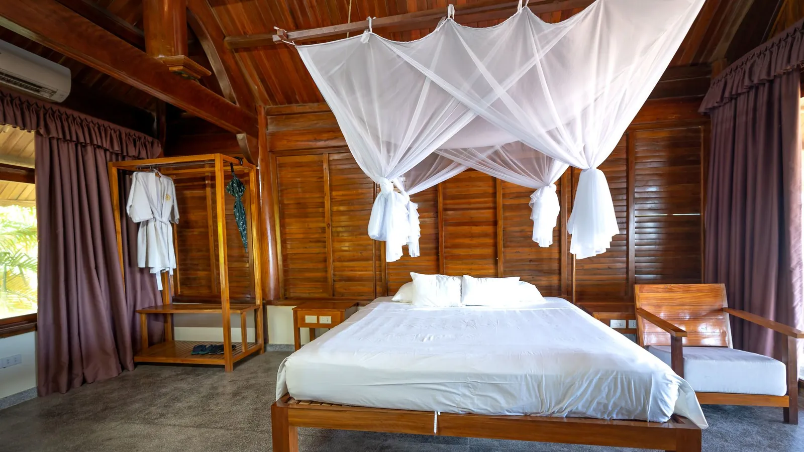 Illustrative photo of a wooden bedroom with a mosquito-net canopy